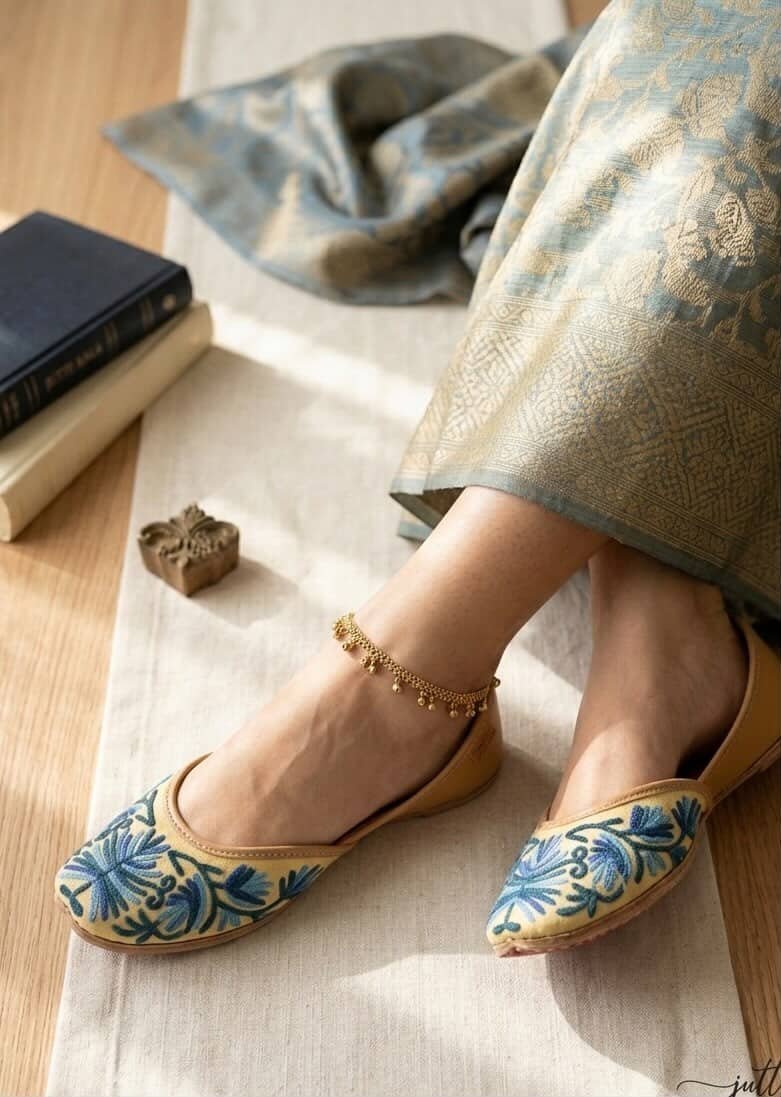 Close-up of blue floral embroidery on beige leather jutti