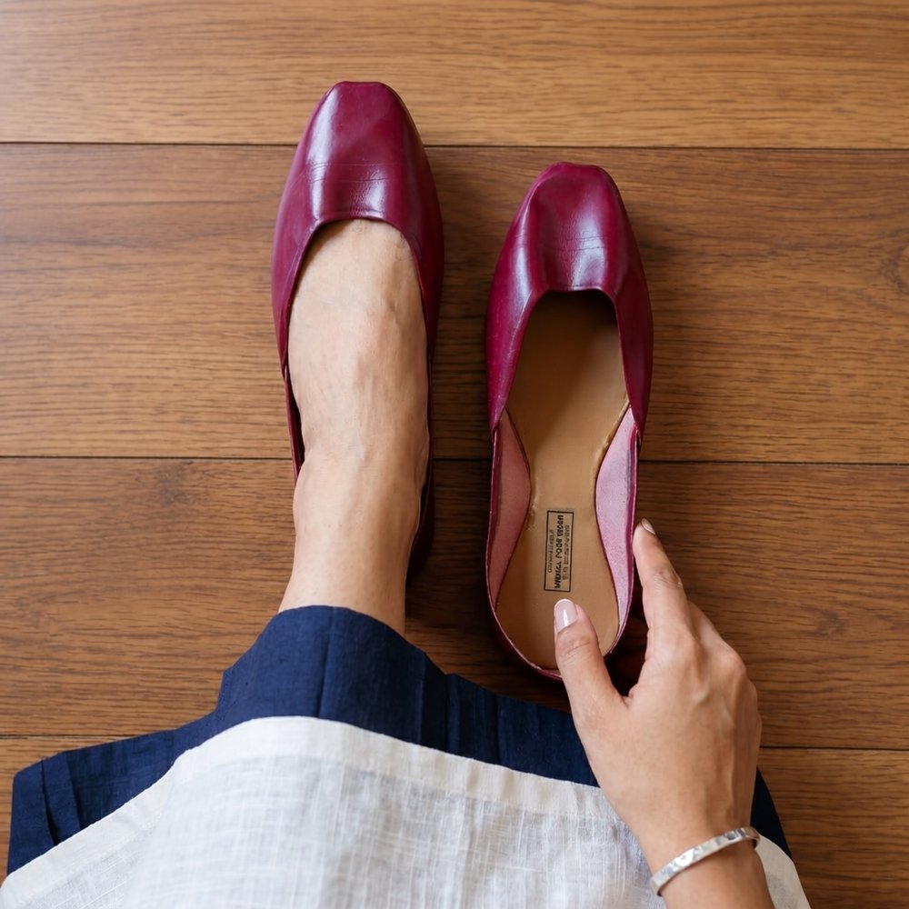 Handcrafted maroon leather flats shown in lifestyle setting with soft leather finish and elegant design