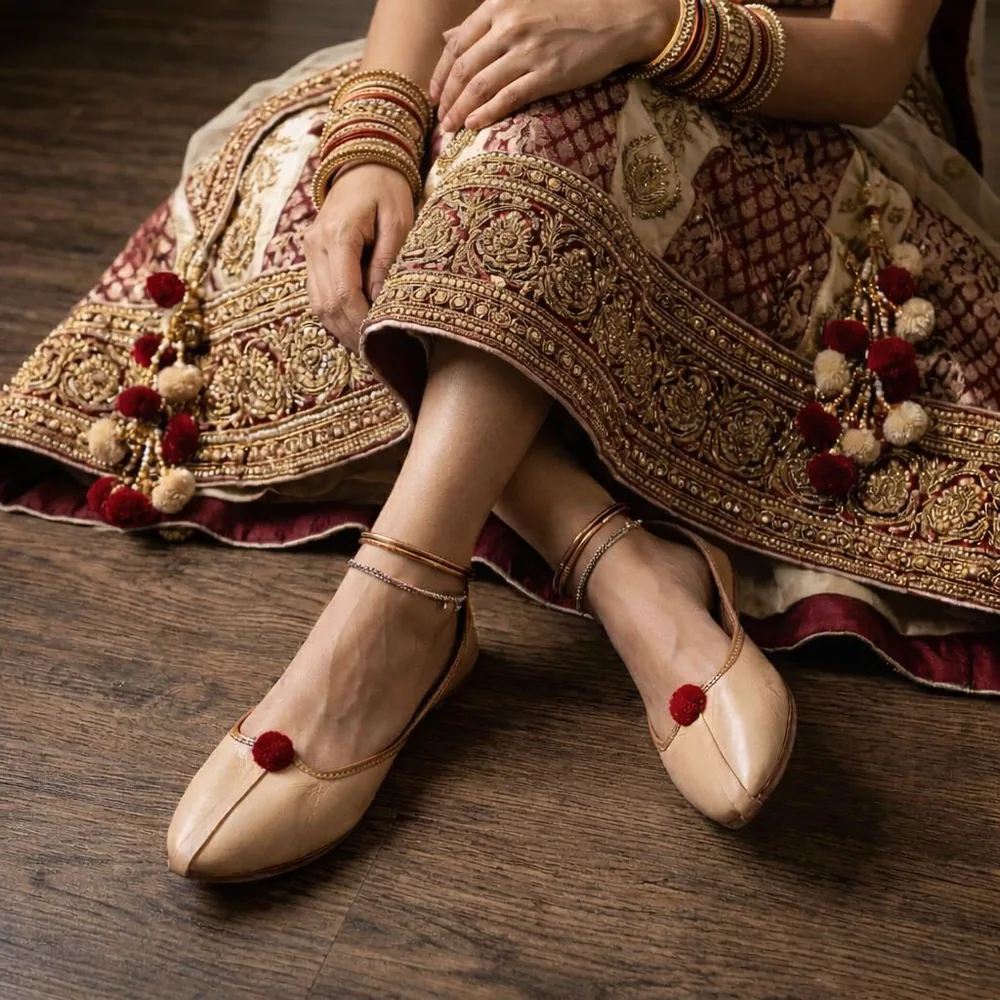 Beige soft leather Punjabi jutti for women with red pom pom, handcrafted ethnic footwear paired with traditional lehenga